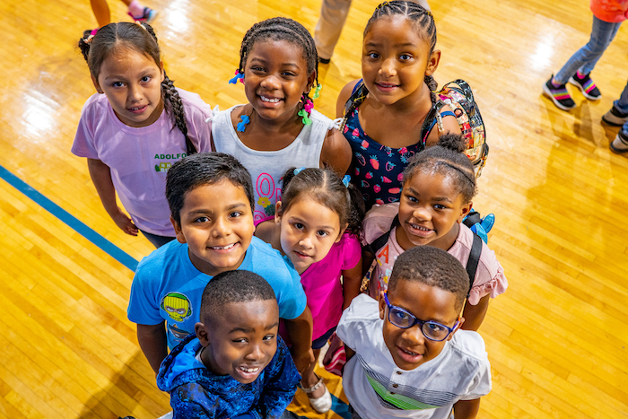 8 Club kids smiling up at the camera