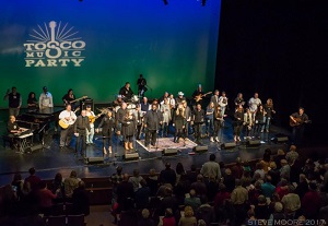 A group of people standing on a stage with musical instruments