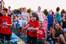 A child dances in a crowd of people