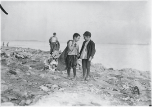 A photograph of two boys standing on a trash pile