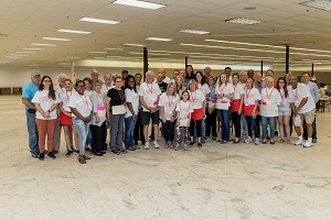 A group of people in a warehouse pose for the camera