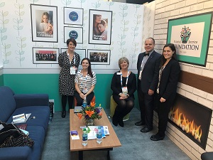 A group of people sit and stand in a living room